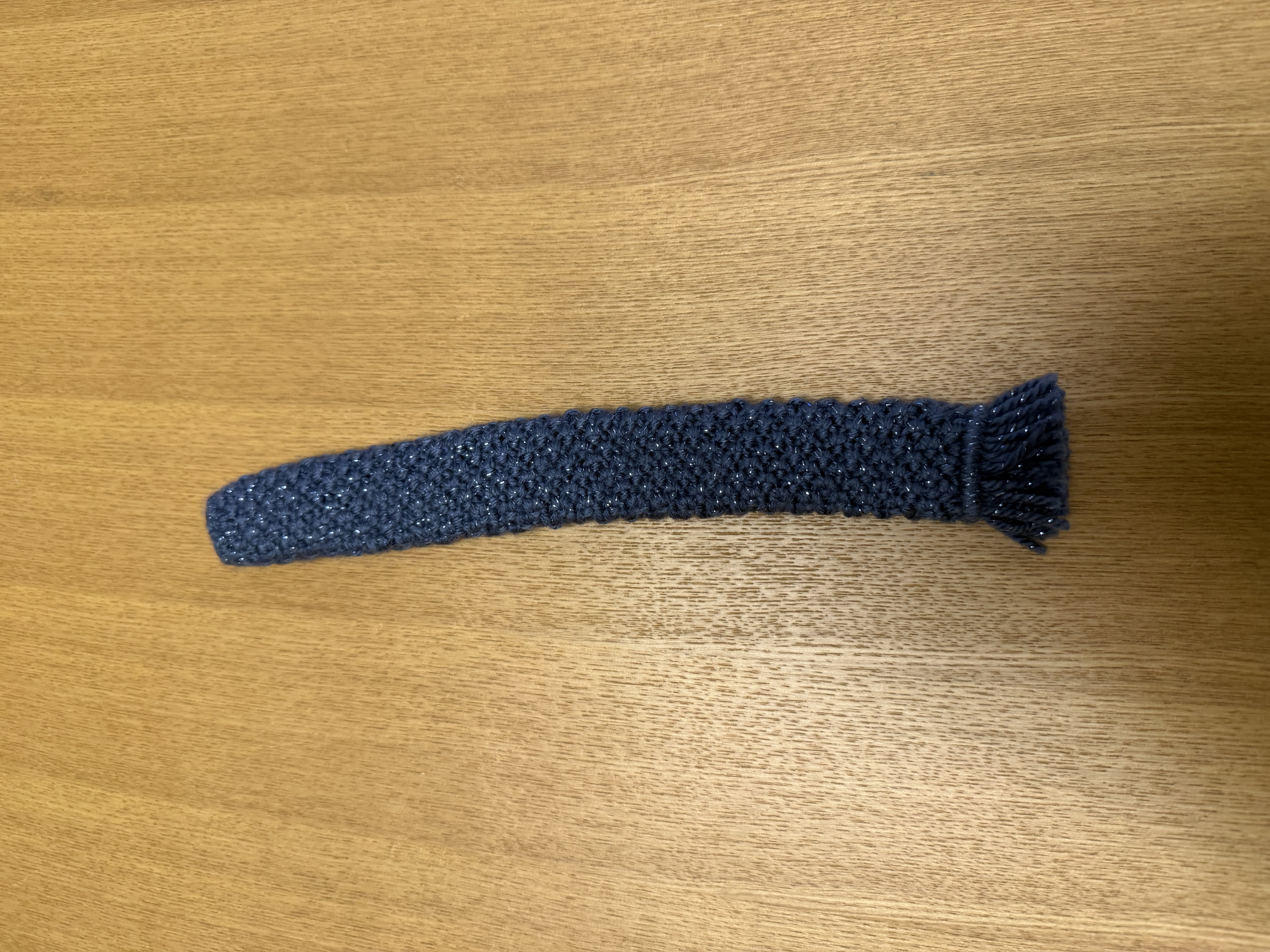 2025年10月に追加購入した、ラメ入りネイビーのグリップカバーを木製のテーブルに置いて撮った写真。