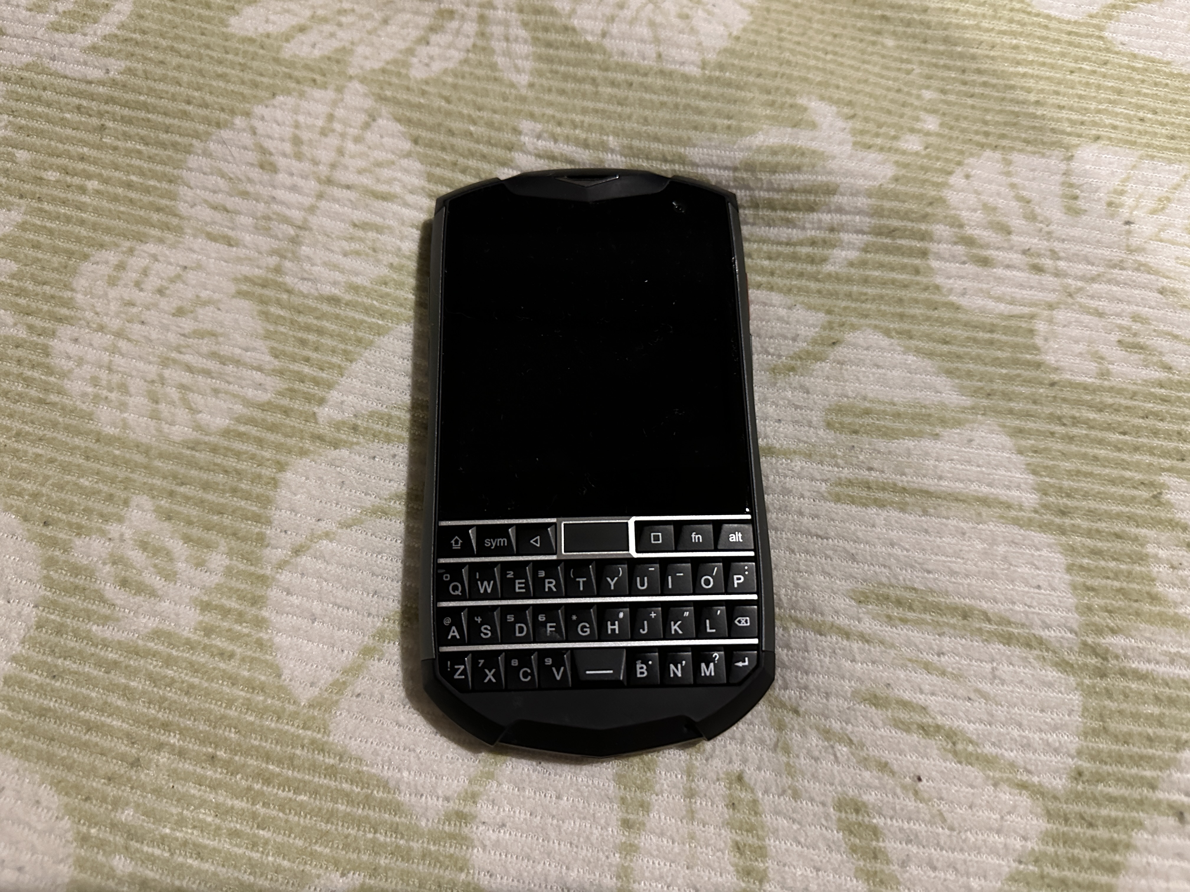 故障したTitan Pocketの写真。上半分がディスプレイ、下半分がqwerty式の物理キーボードになっています。