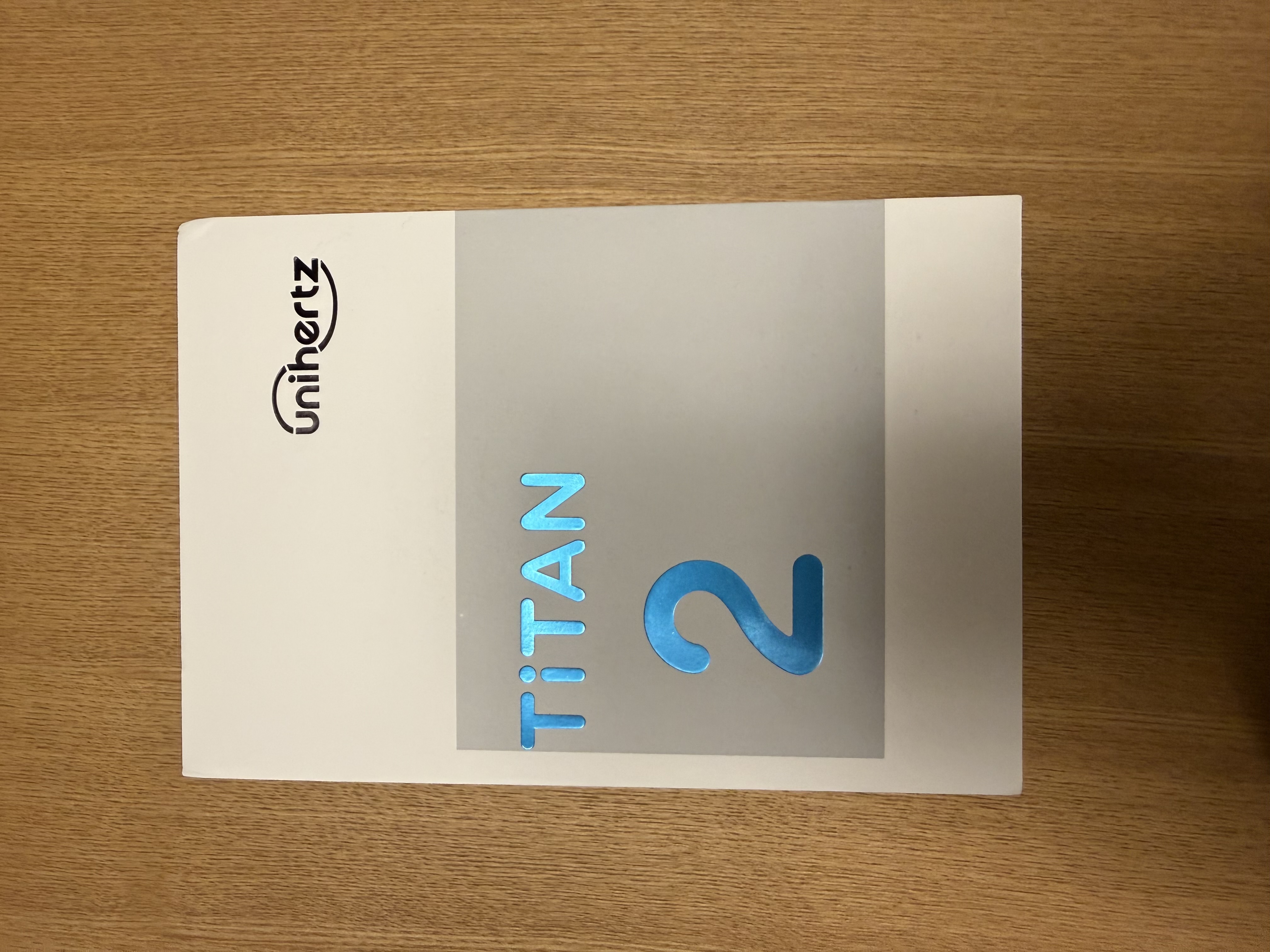 Titan2の化粧箱を撮影した写真。白を基調とした箱で、中央にはグレーのエリアに青文字で商品名が記載されています。クリック/タップすると画像が切り替わります。